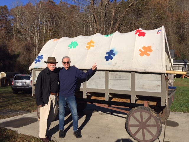 Norman and David strike a pose in front of the
                  Full Spectrum Farm's old wagon